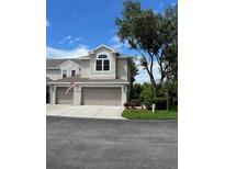 Charming two-story townhome with attached two-car garage and American flag at 3665 Country Pointe Pl, Palm Harbor, FL 34684