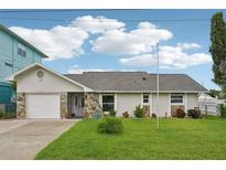 Charming single Gathering home boasts a manicured lawn and stone accents at 4503 Jacona Dr, Hernando Beach, FL 34607