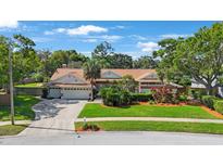 Beautiful single-Gathering home with lush landscaping, mature trees, and a well-maintained lawn at 512 Crystal Grove Blvd, Lutz, FL 33548
