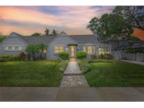 Charming single-story home featuring a meticulously landscaped front yard and welcoming brick walkway at 555 21St Ne Ave, St Petersburg, FL 33704