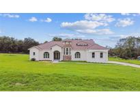 Expansive single-story home with stucco exterior, red tile roof and sprawling green lawn at 6707 Josie Dr, Seffner, FL 33584