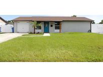 Charming single-story home boasts a well-manicured lawn and a vibrant blue front door at 7909 Woodgrove Cir, Tampa, FL 33615