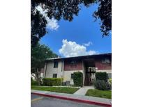 Apartment complex exterior with lawn and trees on a sunny day at 8636 Tahoe Ct # 13, Tampa, FL 33614