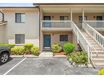 Inviting condo with exterior stairs, a balcony, and landscaped plantings at 9804 Lombard Ct # 104, Tampa, FL 33618