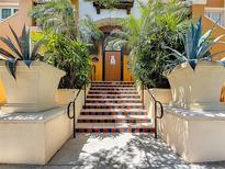 Inviting building entrance featuring tile stairs, lush landscaping, and decorative planters at 100 4Th S Ave # 312, St Petersburg, FL 33701