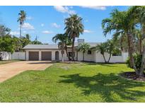 Charming single-story home with a well-manicured lawn and mature palm trees at 109 13Th St, Belleair Beach, FL 33786