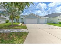 Charming single-story home featuring a three-car garage, manicured lawn, and a welcoming entryway at 11336 Callaway Pond Dr, Riverview, FL 33579