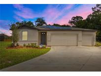 Charming single-Gathering home featuring a three-car garage, solar panels, and a well-manicured lawn at 12277 Spring Hill Dr, Spring Hill, FL 34609