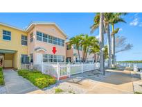 Charming waterfront condo with a white picket fence and lush tropical landscaping at 19417 Gulf Blvd # B110, Indian Rocks Beach, FL 33785