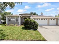 Charming single-story home featuring a well-manicured lawn and a three-car garage at 27826 Sora Blvd, Wesley Chapel, FL 33544