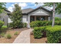 Charming single-story home with lush landscaping and a brick walkway leading to the front door at 3037 Riders Pass, Odessa, FL 33556