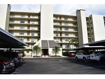 Exterior view of a multi-story building with covered parking and well-maintained landscaping at 3200 Cove Cay Dr # 5F, Clearwater, FL 33760