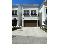 Townhome featuring a two-car garage and bright, white exterior at 8405 Costa Bella Way, Temple Terrace, FL 33637