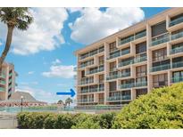 Condo exterior featuring multiple stories, manicured hedges, and teal balconies at 1 Key Capri # 302E, Treasure Island, FL 33706