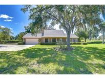 Charming single-story home with a well-manicured lawn, mature trees, and a two-car garage at 3125 S Miller Rd, Valrico, FL 33596
