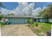 Charming single-story home with a two-car garage and a lush green yard at 3144 Abeline Rd, Spring Hill, FL 34608