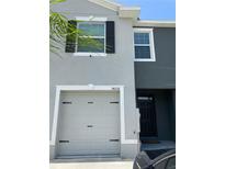 Two-story home featuring a one-car garage, a contrasting color scheme and shuttered windows at 34252 Redwood Dawn Ln, Wesley Chapel, FL 33543