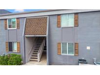 Two-story condominium showcases stairs to the entrance, complemented by wood shutters on the windows at 3805 Cortez Cir # B, Tampa, FL 33614