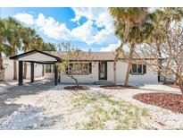 Charming home with tropical landscaping, white rock and palm trees creating a serene curb appeal at 463 85Th Ave, St Pete Beach, FL 33706
