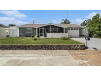 Charming single-story home featuring a screened porch, landscaped yard, and a one-car garage at 5128 Billings Dr, Holiday, FL 34690