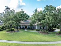 Charming single-story home with a lush lawn, mature trees, and a welcoming front porch at 5927 Flatwoods Manor Cir, Lithia, FL 33547