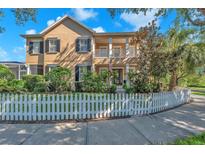 Charming two-story home with a white picket fence, manicured landscaping, and a welcoming front porch at 6207 Bleeker St, Riverview, FL 33578