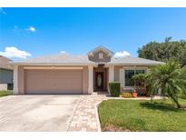 Charming single-story home featuring a two car garage, brick walkway, and well maintained lawn at 6351 Desert Peace Ave, Land O Lakes, FL 34639