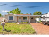 Charming single-story home with a well-maintained lawn, carport, and a brick driveway at 6730 10Th Avenue S Ter, St Petersburg, FL 33707