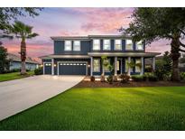 Beautiful two-story home featuring a manicured lawn and a three-car garage in a lush neighborhood at 8332 Swiss Chard Cir, Land O Lakes, FL 34637