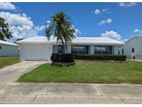 Charming single-story home featuring a well-maintained lawn, white exterior, and blue shutters at 9218 40Th N Way, Pinellas Park, FL 33782