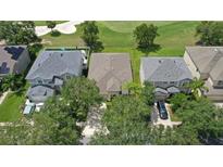 An aerial view of a well-manicured home next to a golf course and perfectly manicured lawn at 10559 Coral Key Ave, Tampa, FL 33647