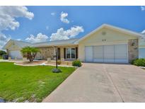 Charming home featuring a well-manicured lawn and a lovely stone accent, complete with an attached two-car garage at 1210 Eastloch Ct, Sun City Center, FL 33573