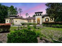 Charming home featuring unique tower, arched windows, and well-manicured landscaping at 13503 Gopher Pond Ct, Hudson, FL 34669