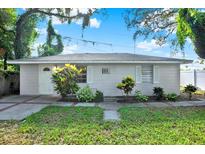 Charming single-story home featuring white trim, flowering bushes and a well-manicured lawn at 1359 S Michigan Ave, Clearwater, FL 33756