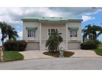 Stylish two-story home featuring a green roof, twin garages, and mature palm trees at 3402 Amberjack Dr, Hernando Beach, FL 34607