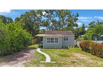 Charming single story home with light-grey exterior, well-maintained landscaping, and a beautiful, mature shade tree at 3544 6Th S Ave, St Petersburg, FL 33711