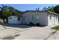 Charming single-story home with a well-maintained exterior, spacious driveway, and a light gray facade at 4802 Drift Tide Dr, New Port Richey, FL 34652