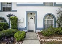 Inviting front entrance with a white door, trimmed in blue and complemented by lush landscaping at 603 Bainbridge Dr, Brandon, FL 33511