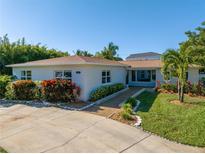 Charming single-story home with lush landscaping, a well-manicured lawn, and a welcoming driveway at 610 Cordova Ne Blvd, St Petersburg, FL 33704