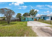 Charming single-story home featuring a blue exterior, well-maintained lawn, and a spacious driveway at 6704 70Th N Ave, Pinellas Park, FL 33781