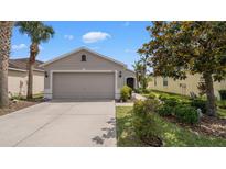 Charming single-story home featuring a well-manicured lawn and a two-car garage at 7120 Forest Mere Dr, Riverview, FL 33578