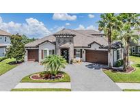 Beautiful Mediterranean style home with tile roof, stone accents, and three-car garage at 7162 Graybrook Dr, Wesley Chapel, FL 33545