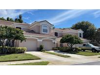 Charming home featuring a symmetrical design, a tile roof, and two-car garage, complemented by well-maintained landscaping at 824 Lantern Way, Clearwater, FL 33765