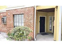 Townhouse exterior with brick accents, black door, and well-maintained landscaping at 8630 Mallard Reserve Dr # 105, Tampa, FL 33614