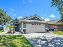 Charming single-story home featuring a well-manicured lawn, paver driveway, and a two-car garage at 8717 Persea Ct, Trinity, FL 34655