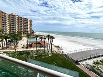 Beautiful beachfront view from a condo balcony featuring palm trees, a pool, and direct beach access at 880 Mandalay Ave # N311, Clearwater Beach, FL 33767