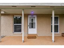 Inviting front entrance with brick facade, white door and columns, and 'HOME' welcome mat at 1116 Jadewood Ave, Clearwater, FL 33759