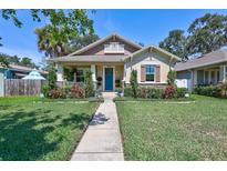 Charming bungalow with a blue front door and well-manicured lawn and landscaped garden at 1119 Highland S St, St Petersburg, FL 33701