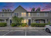 Charming townhome featuring manicured landscaping, a well-lit walkway, and neutral exterior paint at 13905 Abbey Ln, Largo, FL 33771