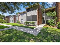 Charming condo with mature trees, gray siding, brick accents, and inviting walkway at 1400 Gandy N Blvd # 809, St Petersburg, FL 33702